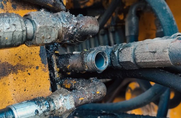 Signs of Wear and Tear in Hose Fittings Close up of pipe system of hydraulic valves in industrial machiner